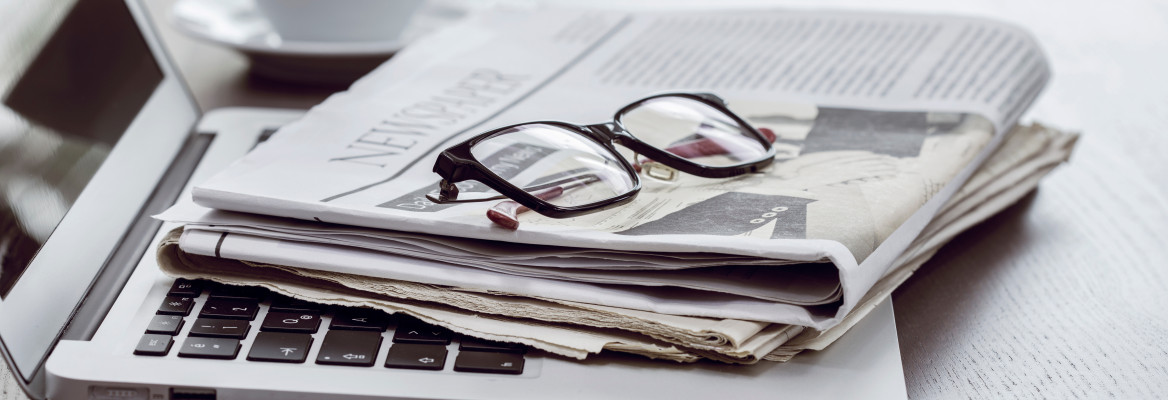 Newspaper with computer on table