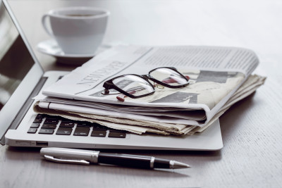 Newspaper with computer on table